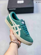 Angled side view of the green sneaker with cream stripes, cream sole, and visible Mexico 66 lettering.