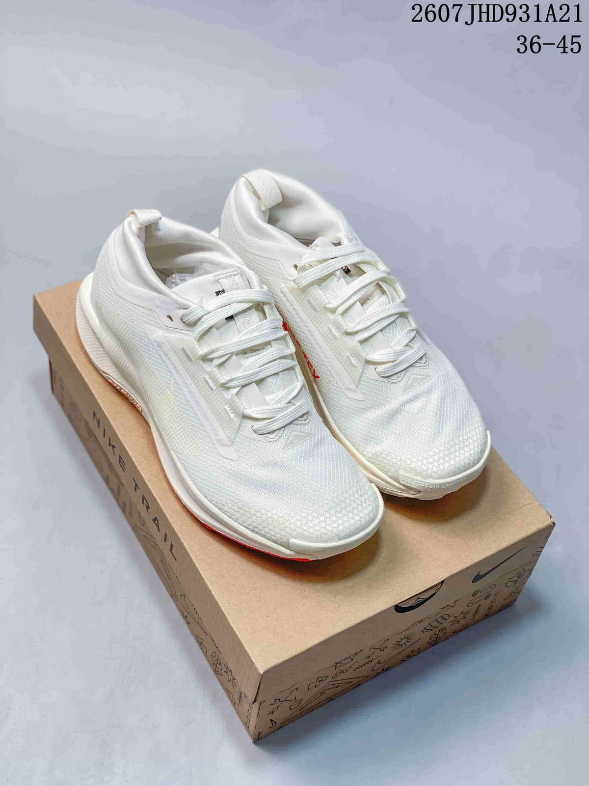 Pair of white Nike sneakers displayed on a Nike shoebox, with red outsole accents and the code 2607JHD931A21 visible in the image.