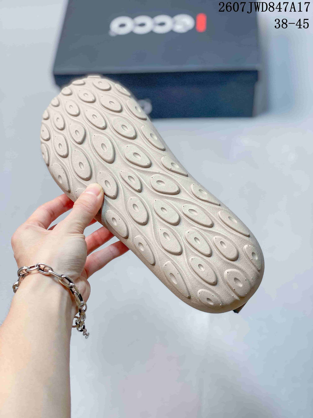 Close-up of the light-colored rubber outsole showing its rounded textured tread pattern.