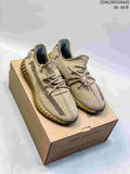 Pair of beige Adidas Yeezy Boost 350 sneakers displayed on a shoe box, showing the knit upper, side stripes, and ribbed tan outsole.