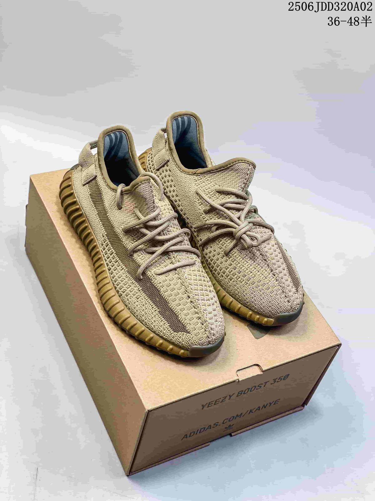 Pair of beige Adidas Yeezy Boost 350 sneakers displayed on a shoe box, showing the knit upper, side stripes, and ribbed tan outsole.