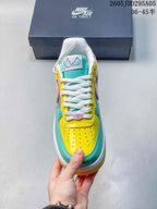 Top view of the sneaker showing white laces, a turquoise tongue, yellow perforated toe box and multicolor paneling.