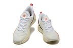 Pair of white Nike LeBron basketball shoes with red accents, shown from the front