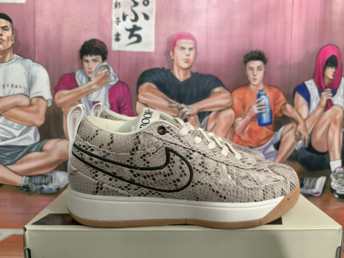 Side view of a gray patterned Nike Book 1 sneaker with black Swoosh, white midsole, and gum-colored outsole.