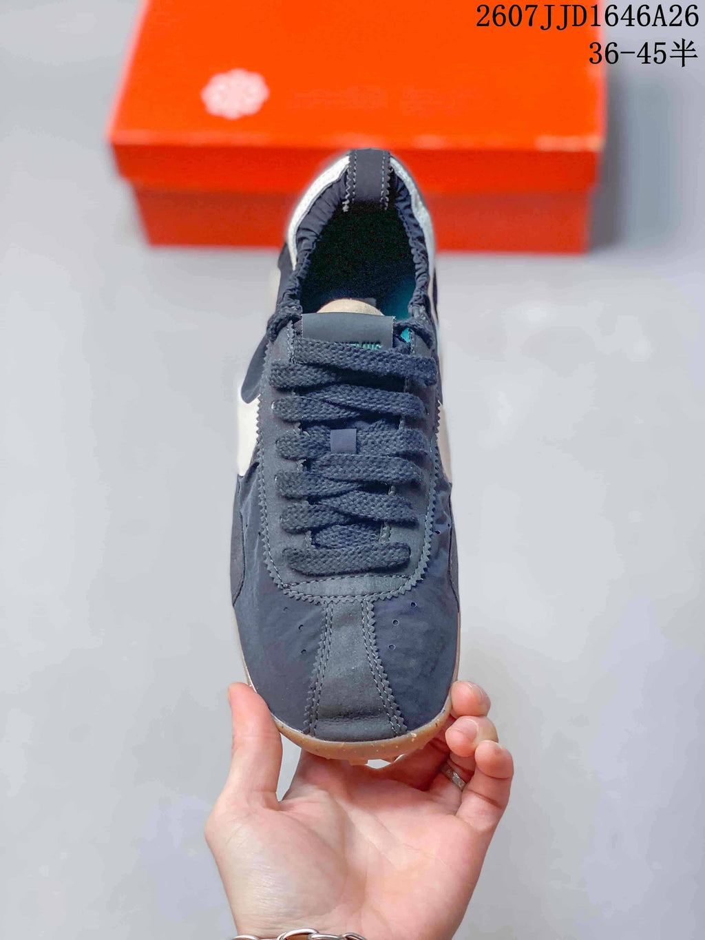 Top view showing the dark lace-up construction, stitched panels, and rounded toe.