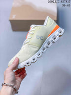 Side profile of the cream low-top sneaker showing the knit-style upper, On branding, orange heel accent, and segmented sole.