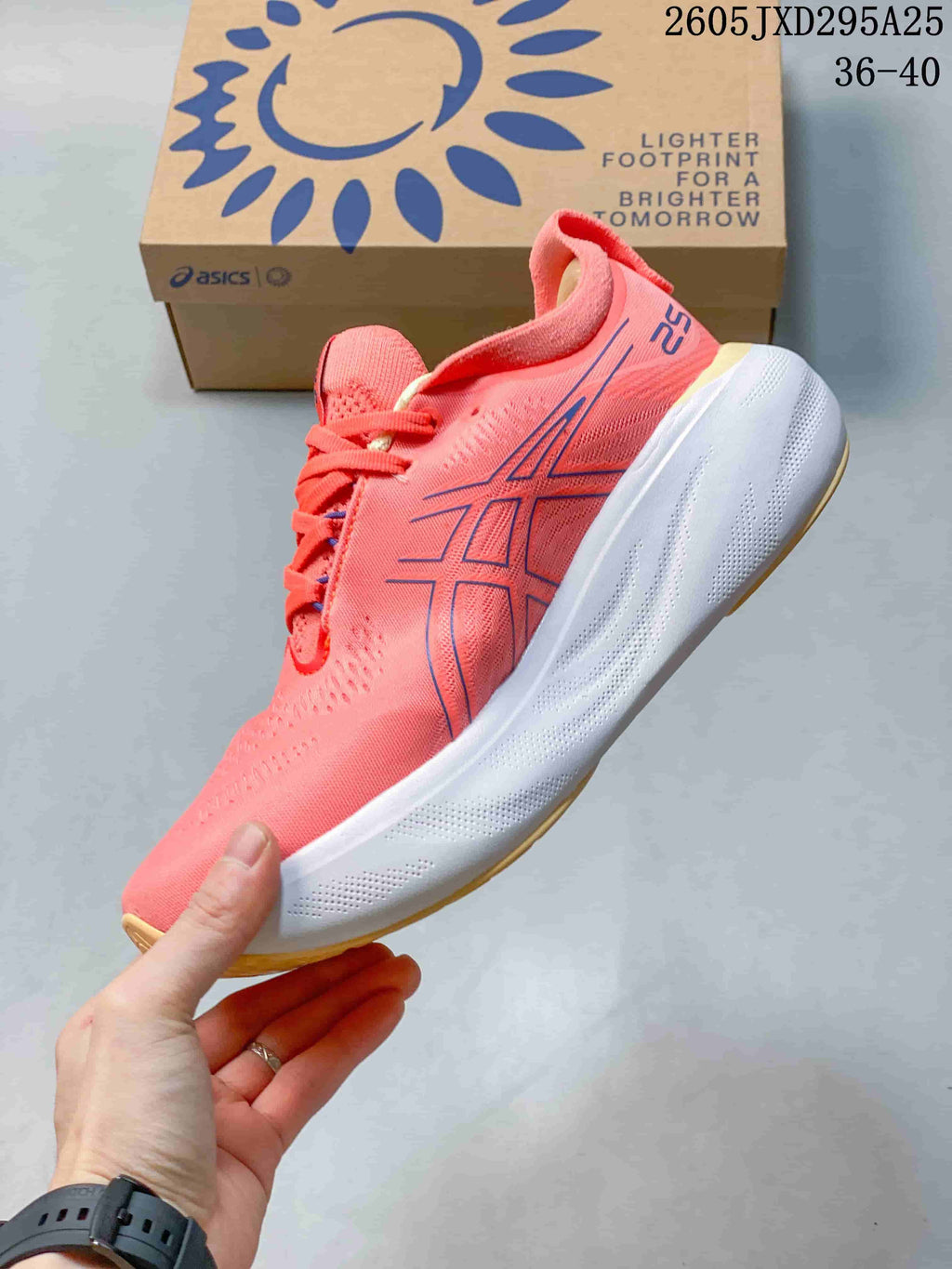 Side view of the coral-pink ASICS shoe with blue logo detailing and white midsole