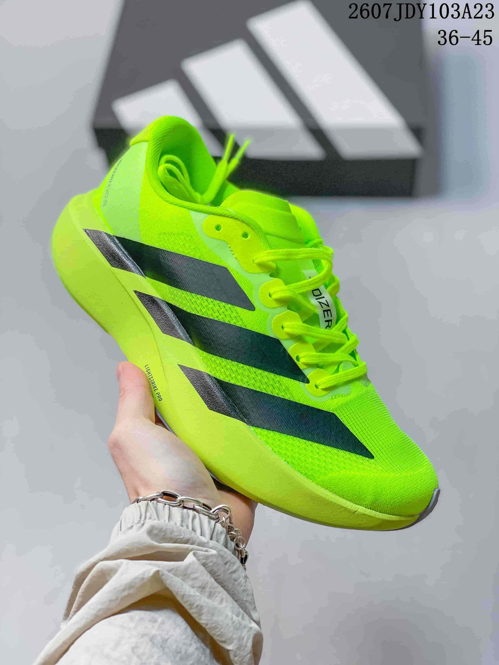 Neon green adidas Adizero low-top sneaker with black side stripes.