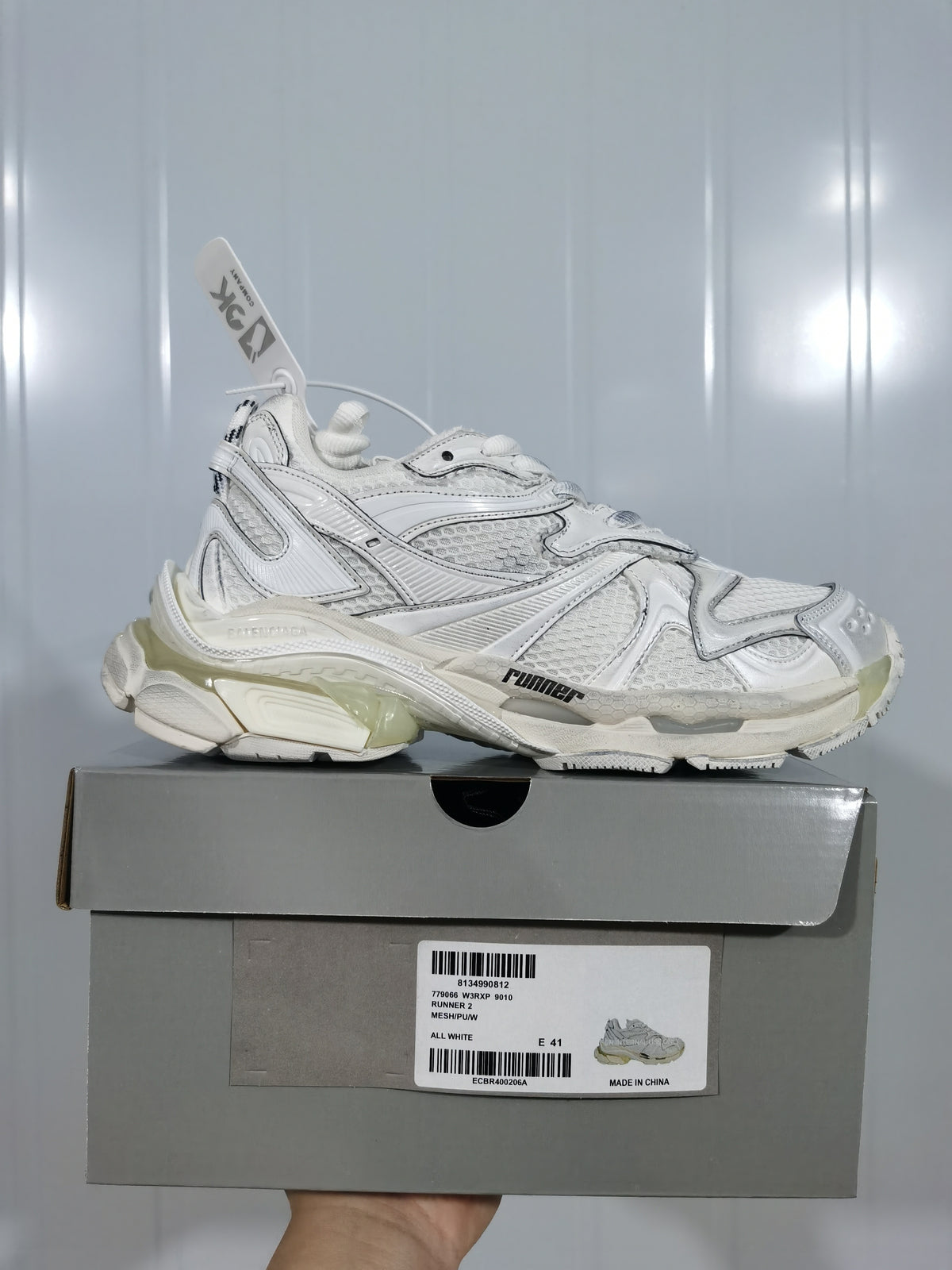 White PUMA sneaker displayed on its box; the box label shows RS-X 2010, ALL WHITE, and EU 41 for the photographed sample.