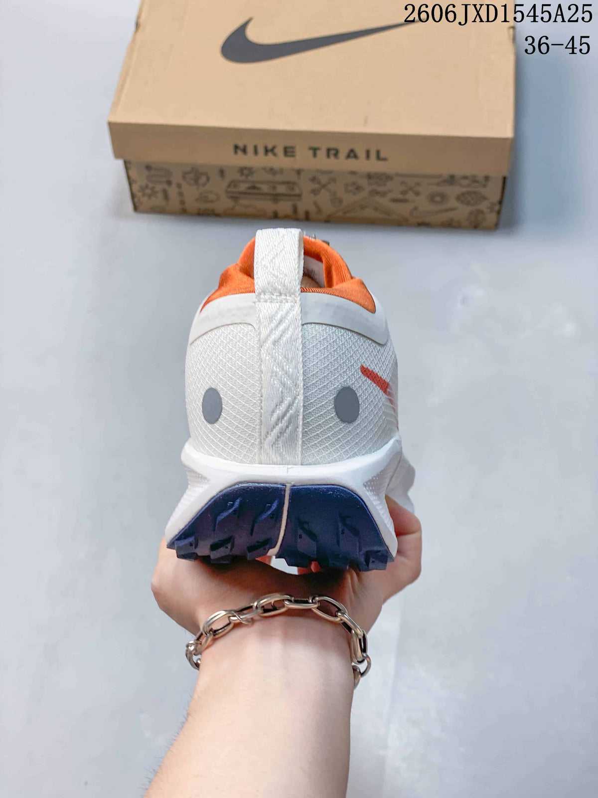 Rear view showing the heel, orange collar and lugged outsole of the trail shoe