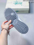 Close-up of the gray rubber outsole showing concentric circular traction at the forefoot and patterned tread under the heel.