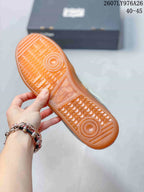 Close-up of the amber-colored outsole showing its textured tread pattern and circular traction zones; image text shows style code 2607LY976A26 and size range 40–45.