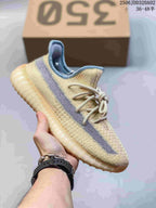 Cream Adidas Yeezy-style sneaker with a gray side stripe and pale ridged sole.