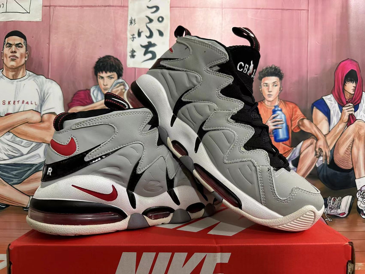 Pair of grey, white, red, and black high-top basketball shoes shown from the side