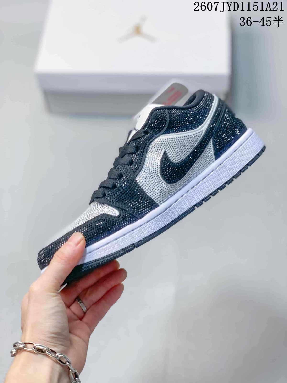 Side profile showing the black and white low-top design, side Swoosh, reflective studded upper, white midsole, and black outsole.