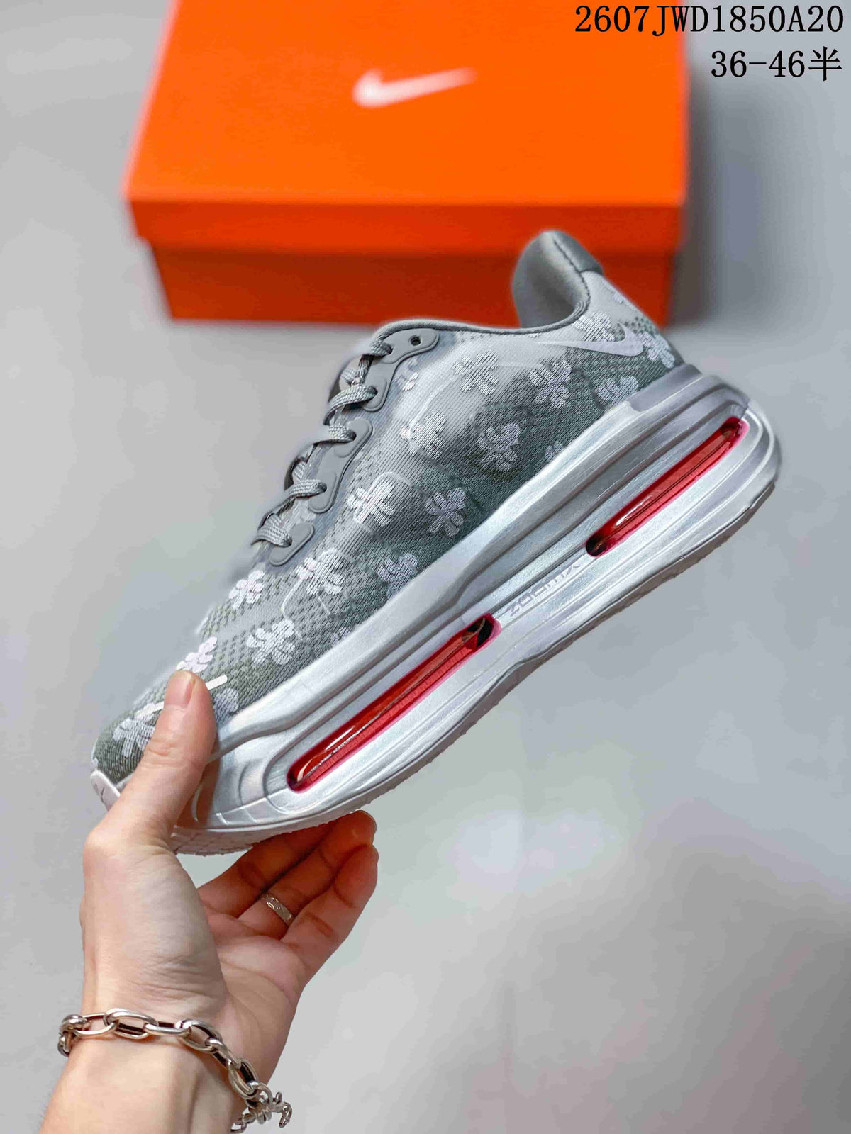 Side profile of the gray floral sneaker showing the layered sole and elongated pink cushioning windows.