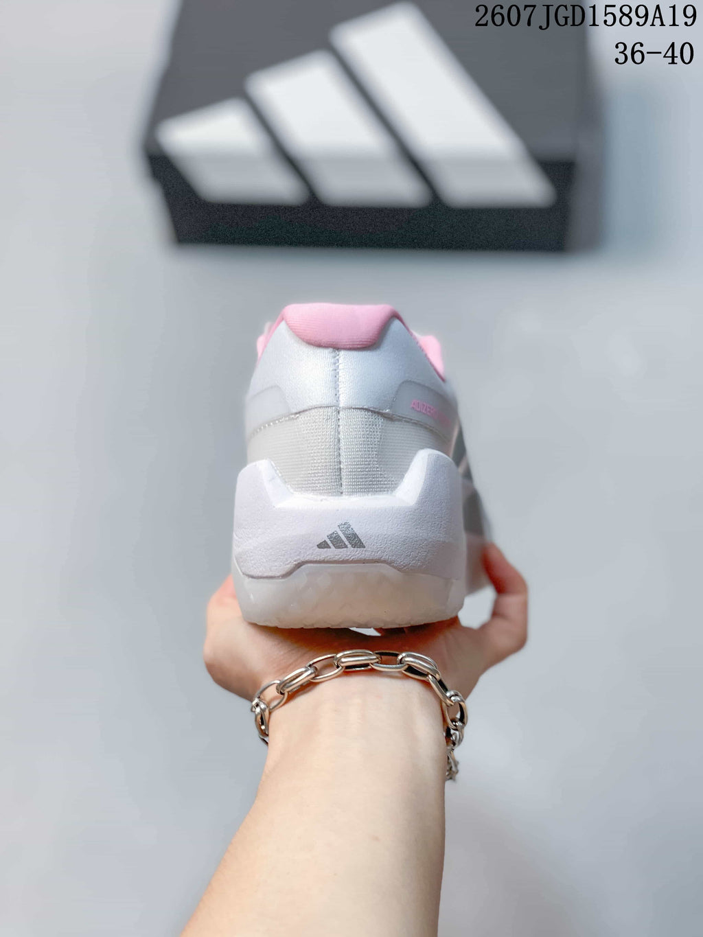 Rear view of the sneaker showing the padded pink collar, white heel structure and adidas logo.