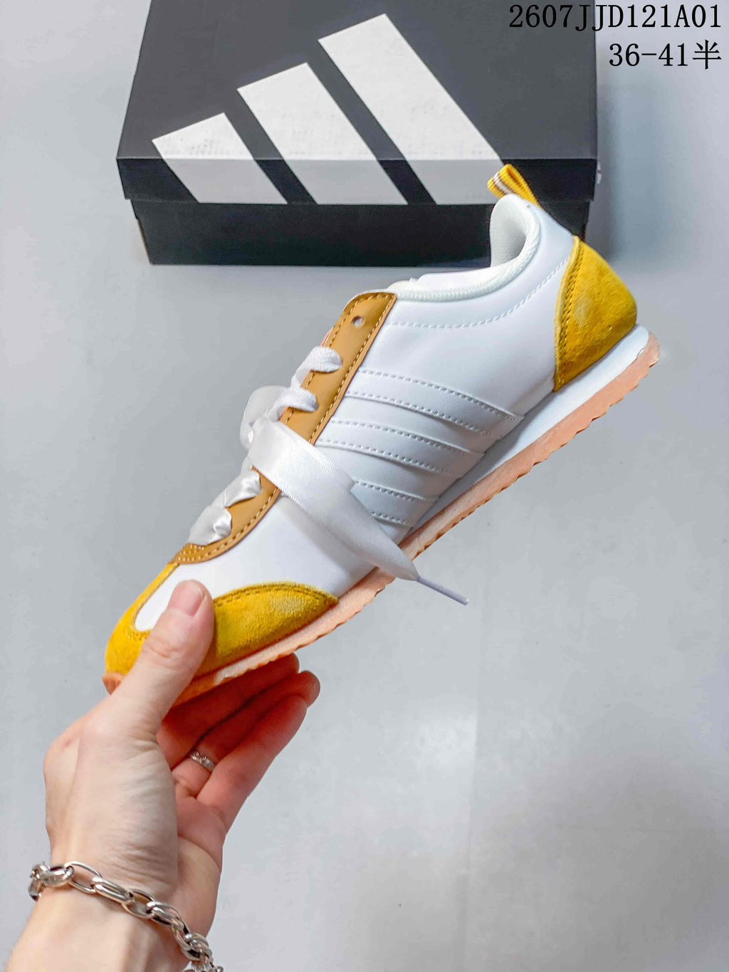 Side profile of the yellow and white adidas VS JOG 2.0 sneaker, showing its three stripes and low-profile shape.
