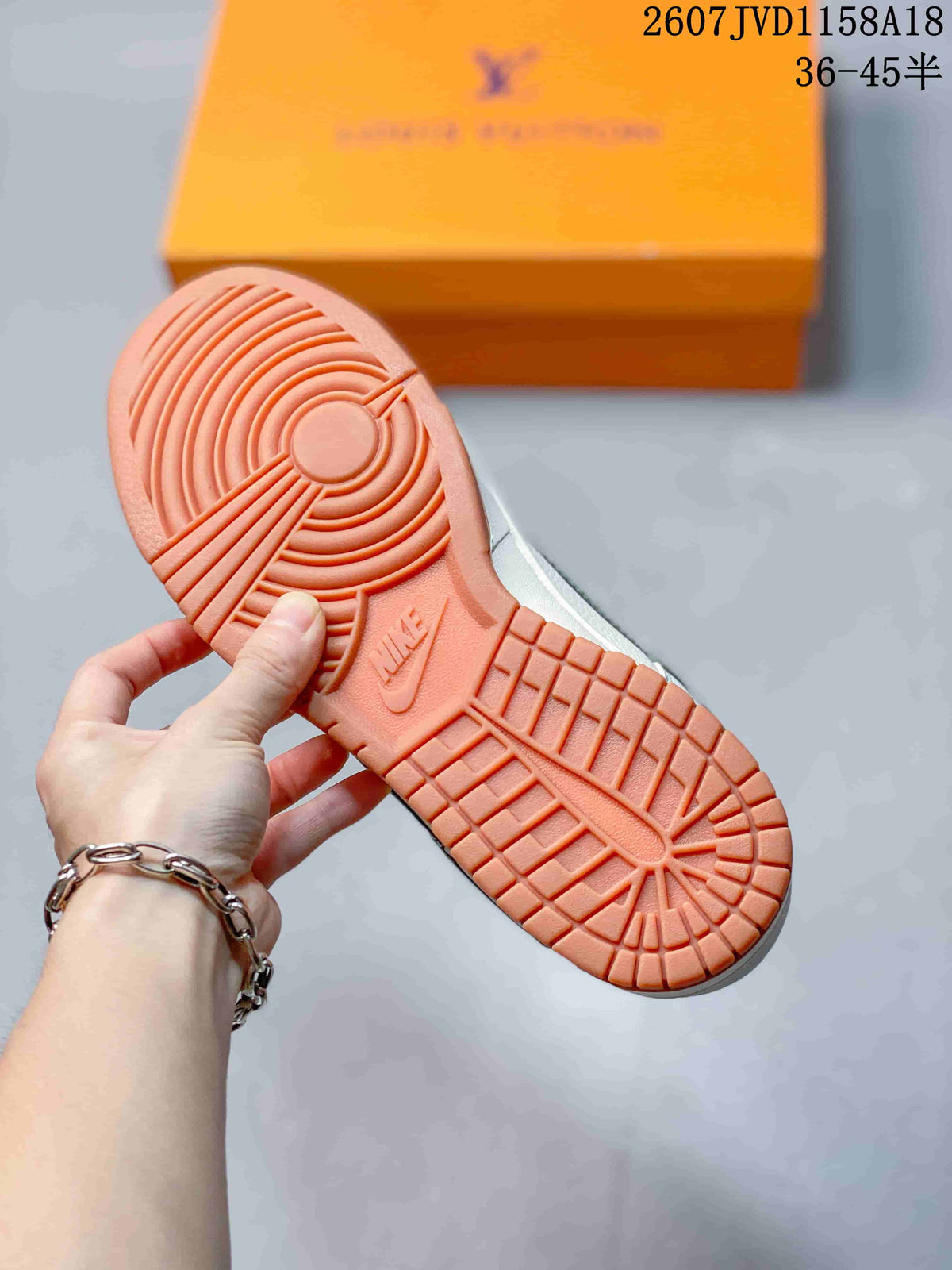 Close view of the gum-colored outsole with circular pivot detail and textured tread; an orange box is in the background.