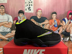 Side profile of a black Nike high-top basketball sneaker with a purple and neon yellow Swoosh and a sculpted dark outsole.