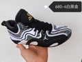Side view of a Jordan basketball shoe in white, black, and gold with patterned panels and black laces