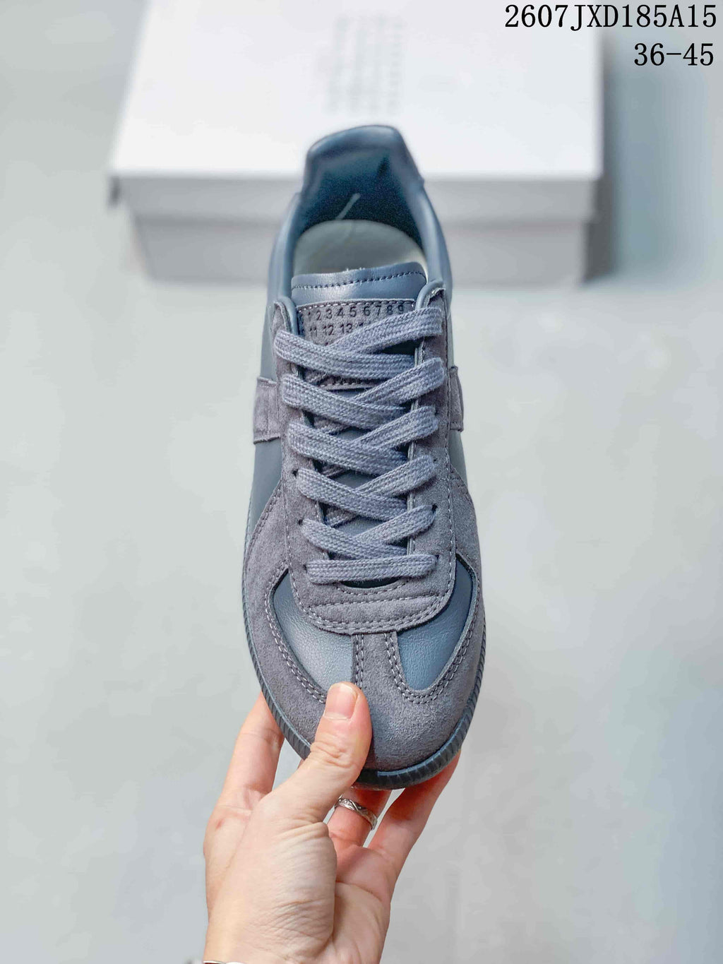 Top view of the gray sneaker showing the lace arrangement, numbered tongue detail, stitched overlays, and rounded toe.