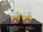 Rear view of yellow Converse training-style shoes with light-colored heel panels and gum-colored soles.