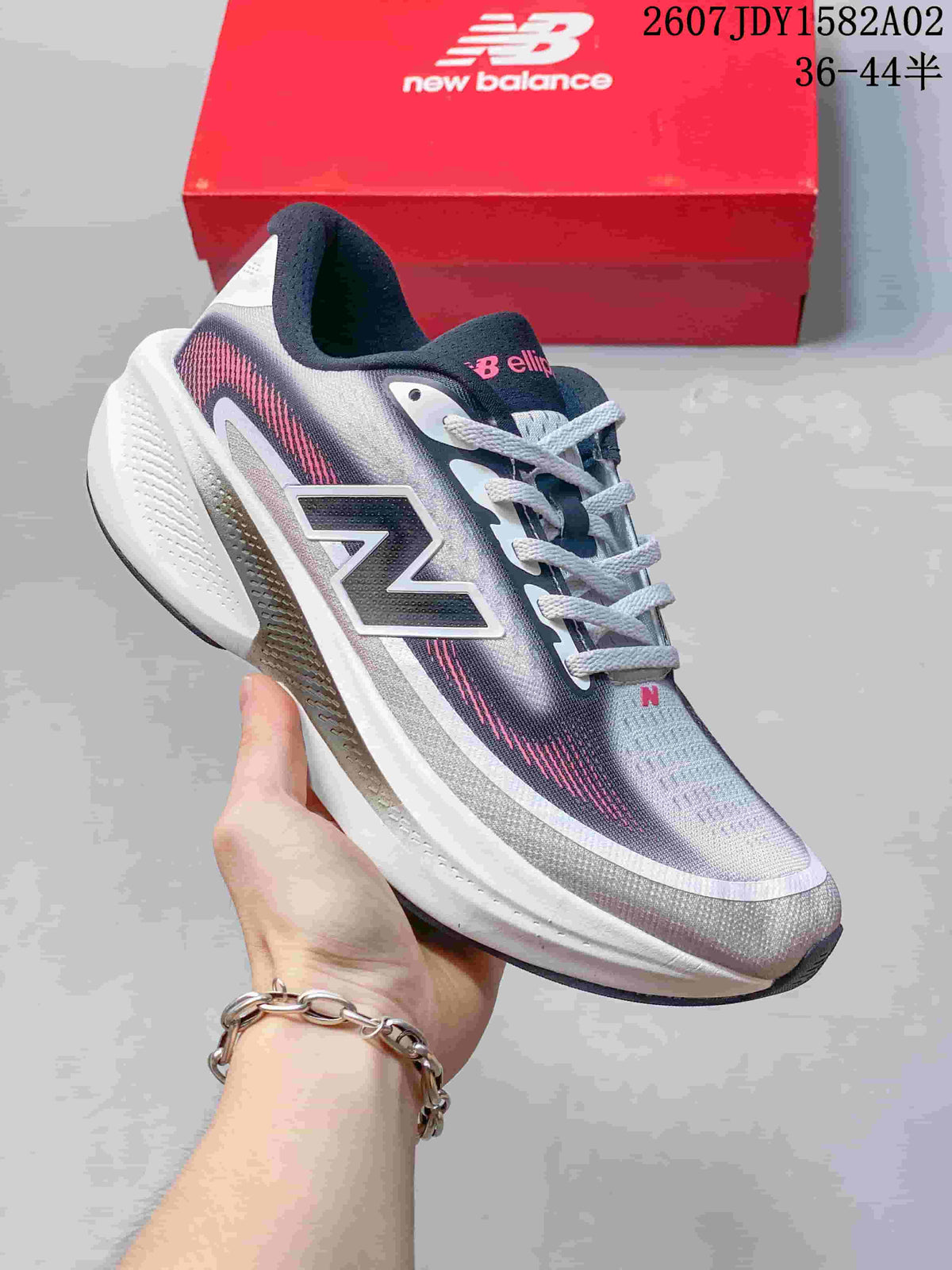 Gray New Balance running shoe with pink and pale gray gradient accents.