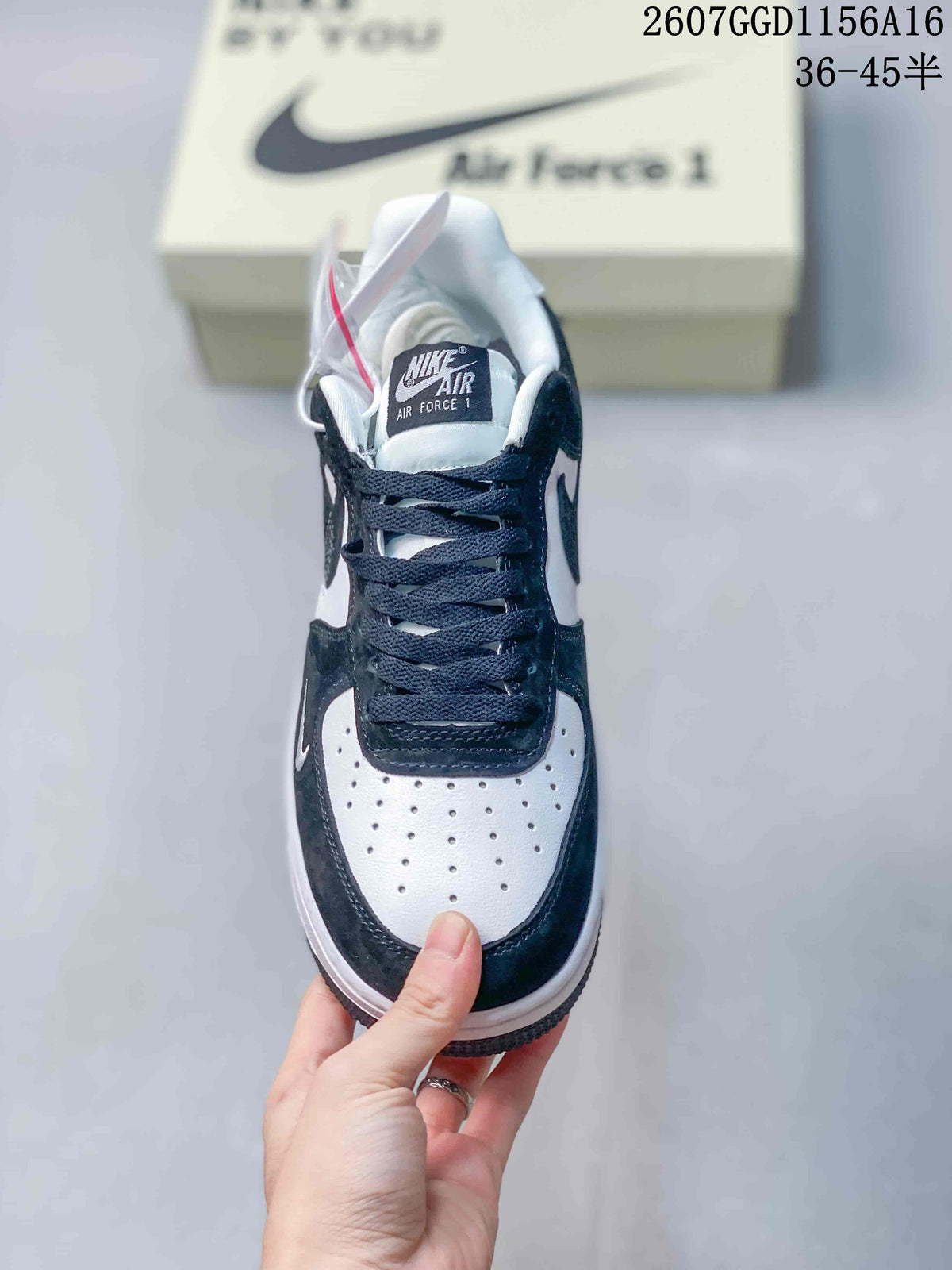 Top view of one sneaker showing the black laces, white perforated toe box, dark overlays, and tongue branding.