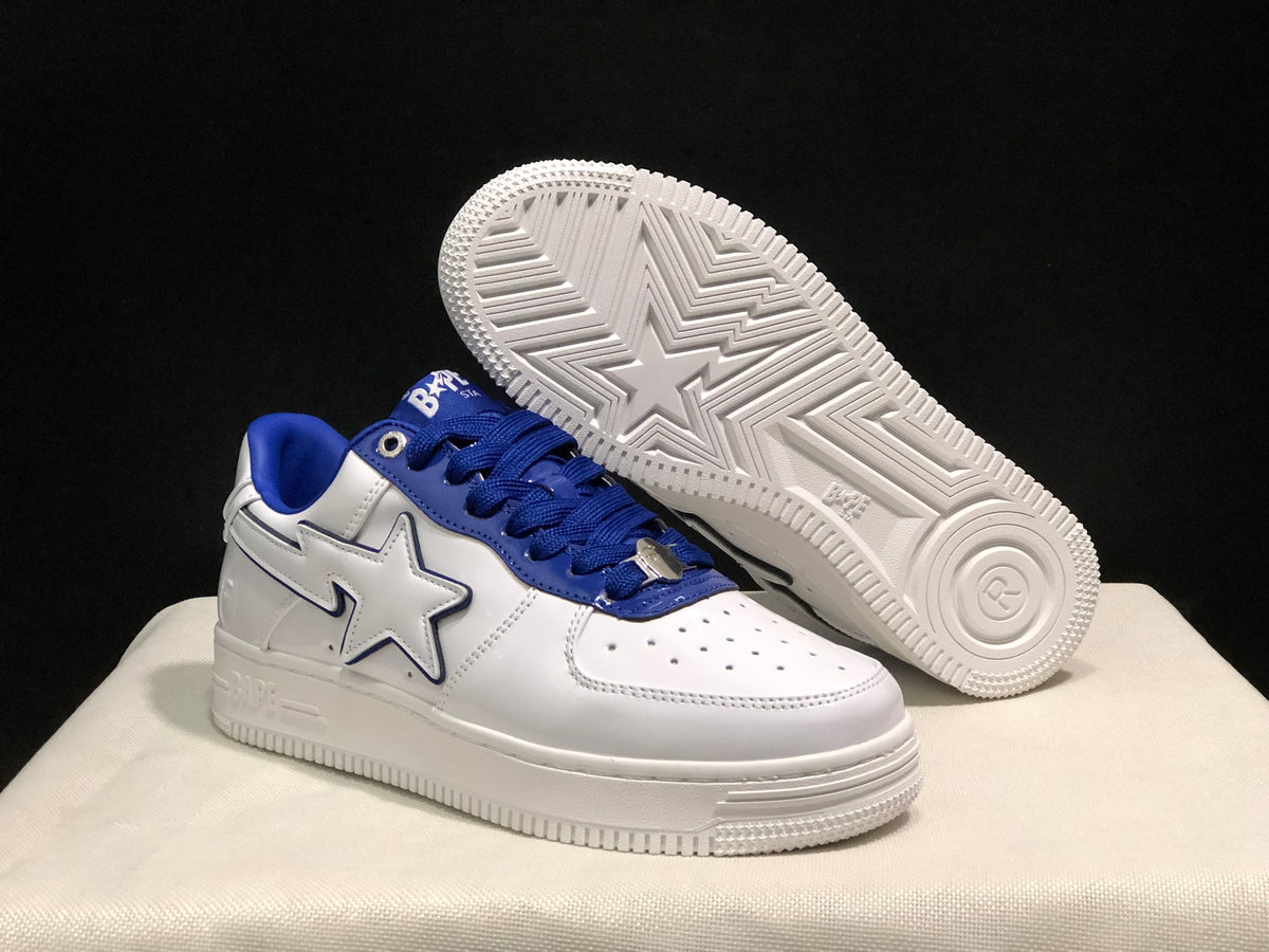 Angled view of a white and blue sneaker with the second shoe lifted to reveal the patterned rubber outsole.