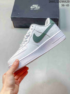 Side view of a white low-top sneaker with a muted green Swoosh, layered upper panels and a raised white sole.