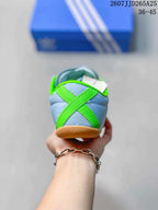 Rear view showing the bright green crossed heel detail and gum-colored outsole.