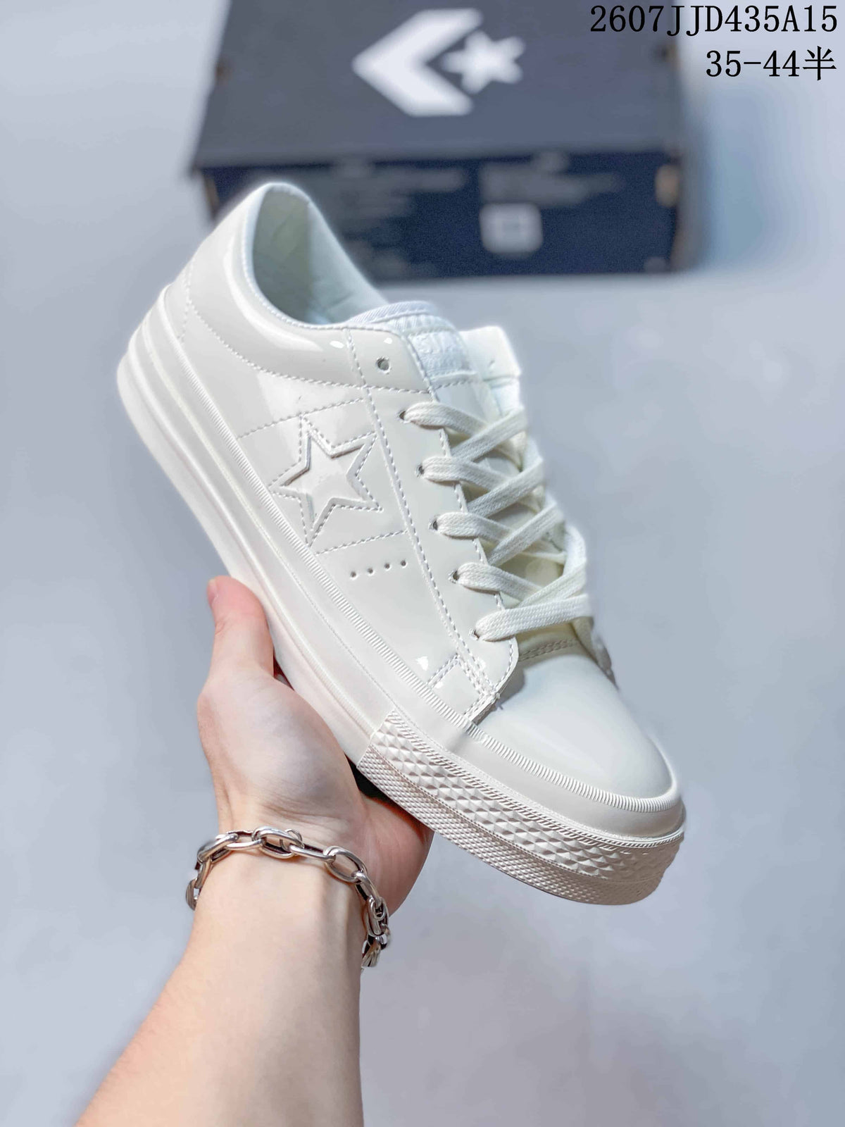 Angled side view of the white Converse One Star J sneaker with star panel detail.