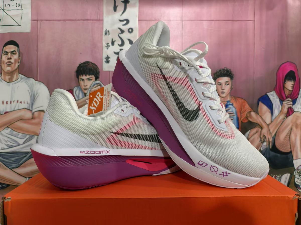 Pair of white Nike running shoes with pink accents and purple-toned soles, shown from the side