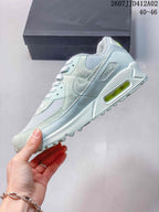 Side view of the Nike Air Max 90 sneaker showing its layered panels and visible heel Air unit.