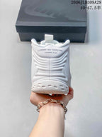 Rear view of a white sneaker with Comme des Garçons Homme Plus text on the heel.