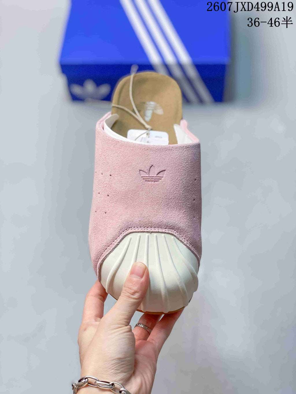 Front view of the pink adidas Adimule mule showing the embossed Trefoil logo, perforated upper, and off-white ribbed toe guard.