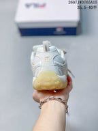 Rear view of the white FILA sneaker showing the heel pull tab, branding, and translucent outsole.