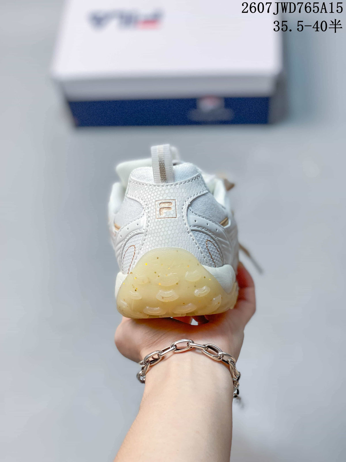 Rear view of the white FILA sneaker showing the heel pull tab, branding, and translucent outsole.
