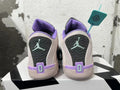 Rear view of pale pink basketball shoes with purple collars, dark heel panels, and mint-colored Jumpman-style marks.