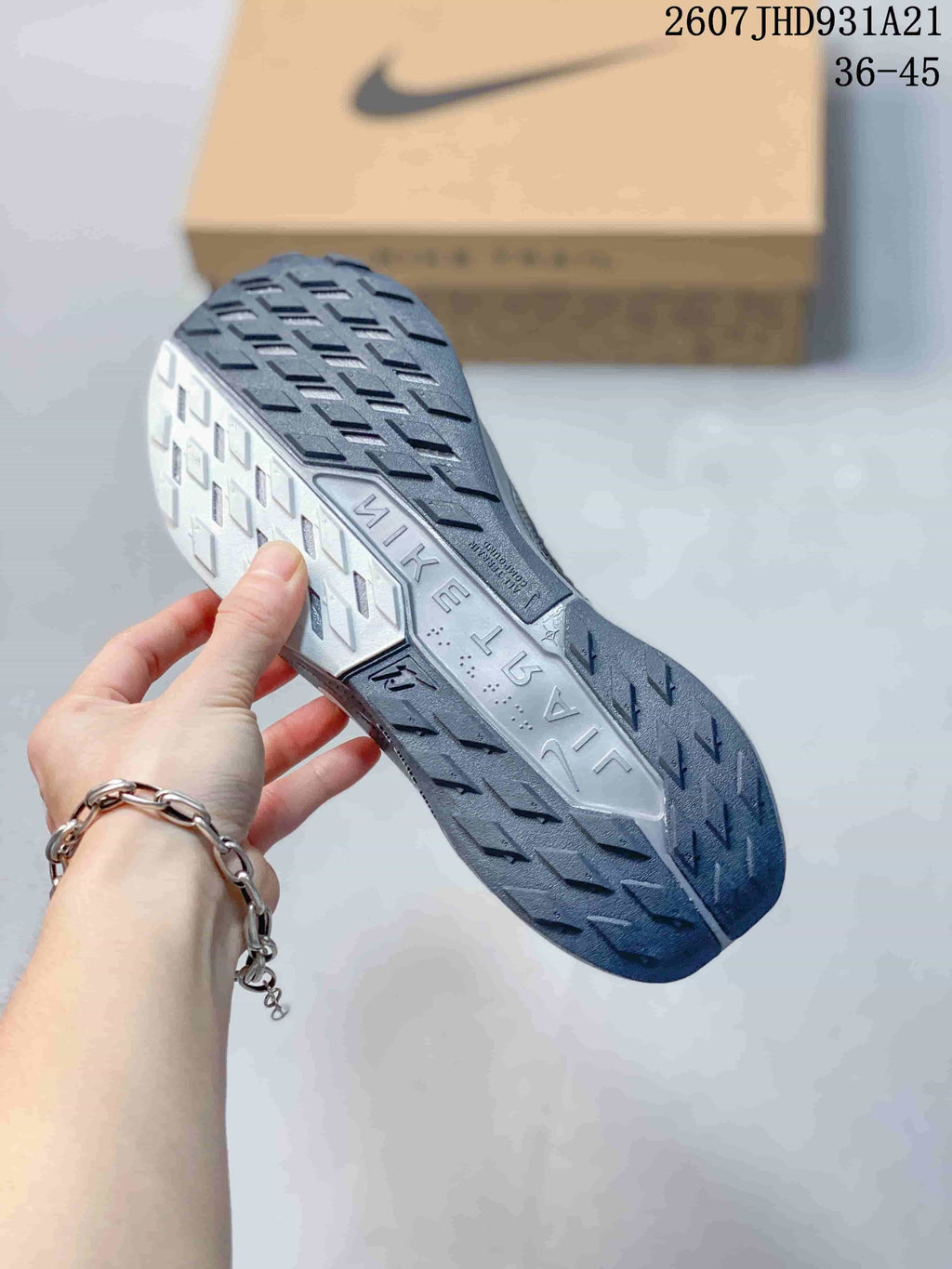 Close view of the sneaker outsole showing a dark and light gray tread pattern with directional lugs.