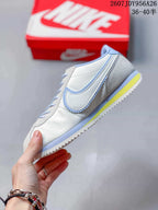 Side view highlighting the white upper, light blue Swoosh trim, and yellow midsole detail.