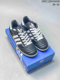 Pair of black and white Adidas Samba sneakers displayed on a blue shoebox.