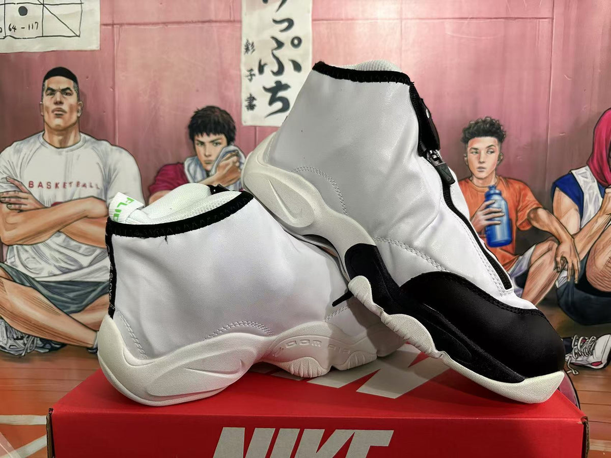 Angled view of white and black Nike The Glove high-top shoes showing the zip-up shroud and outsole