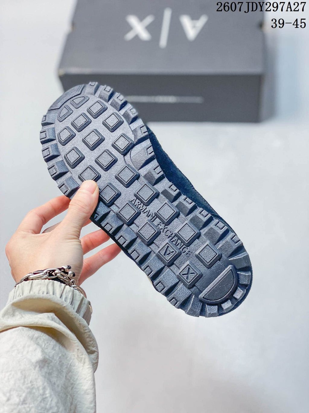 Close view of the sneaker outsole showing a raised geometric tread pattern and Armani Exchange branding.