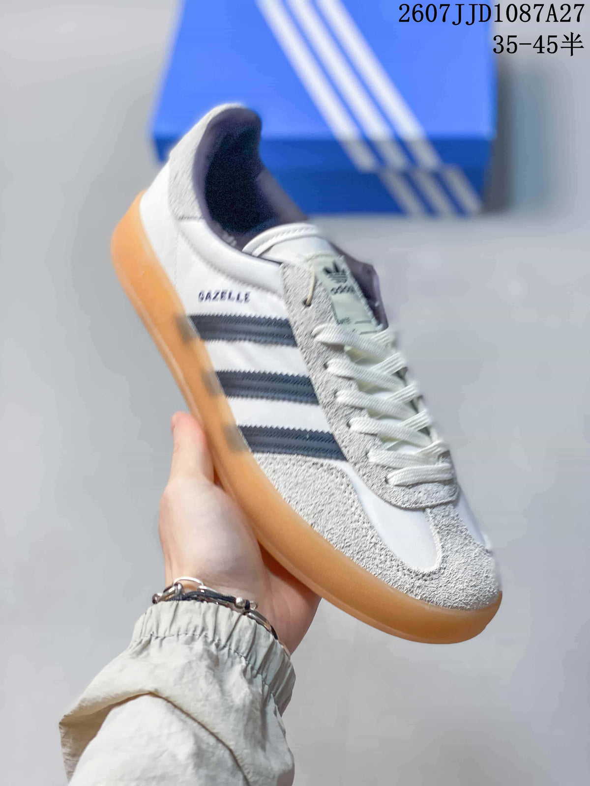 Angled side view showing the white and navy colorway, gum outsole and visible Gazelle side branding.