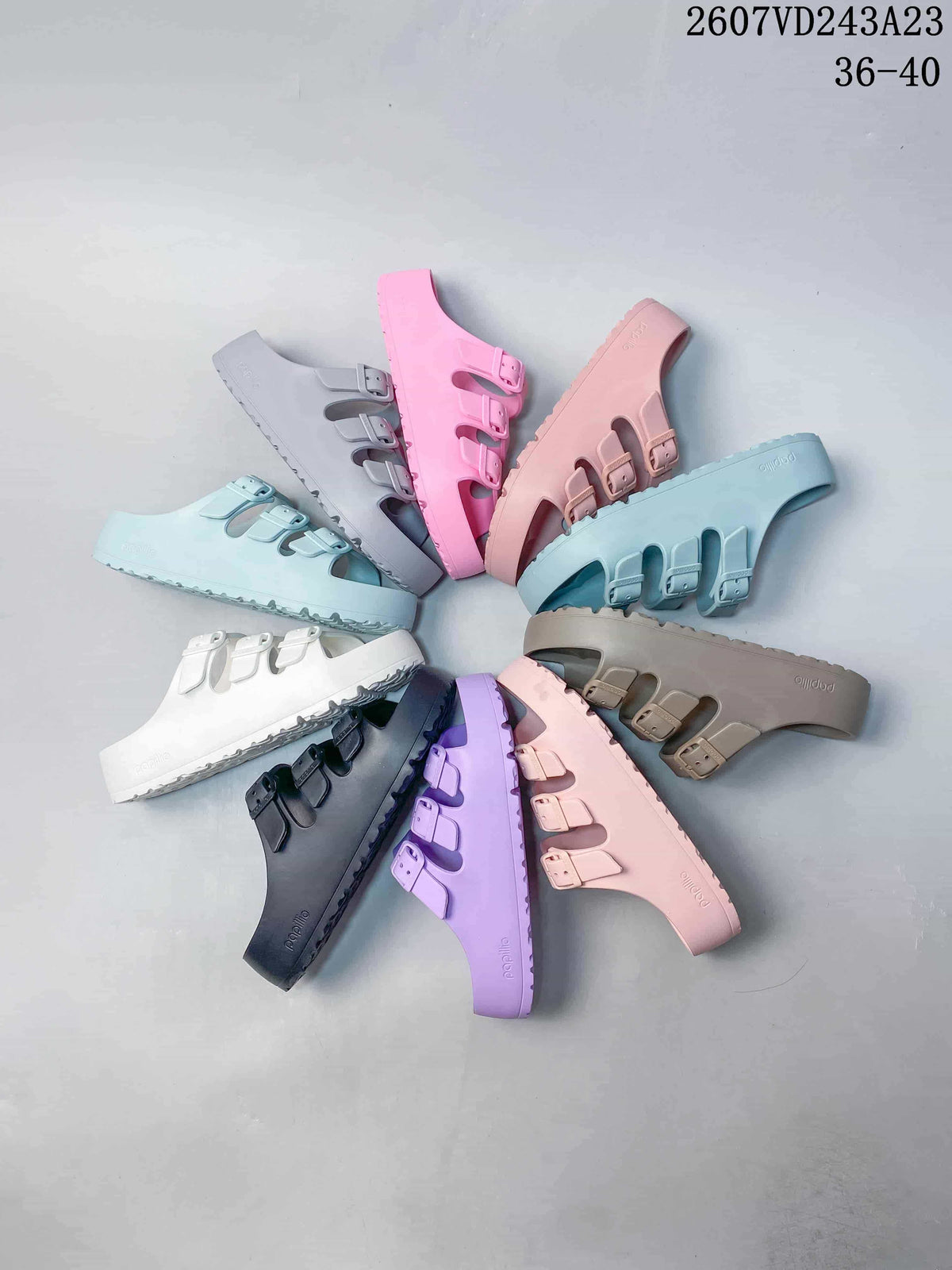 Multiple Papillio sandals arranged in a circle, showing assorted colors and the three-strap design.
