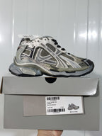 Side view of the New Balance 2000 sneaker displayed on its box; the label identifies it as a runner in taupe mix and shows size C 37.