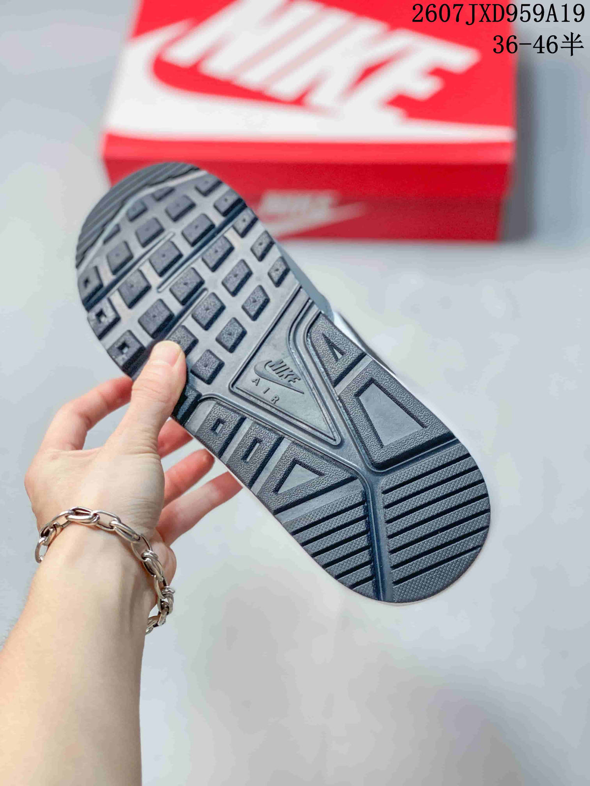 Close view of the patterned rubber outsole on a gray Nike sneaker.