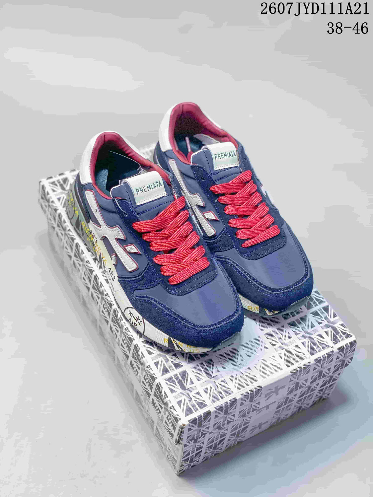 Pair of navy Premiata sneakers with red laces displayed on a patterned shoebox.